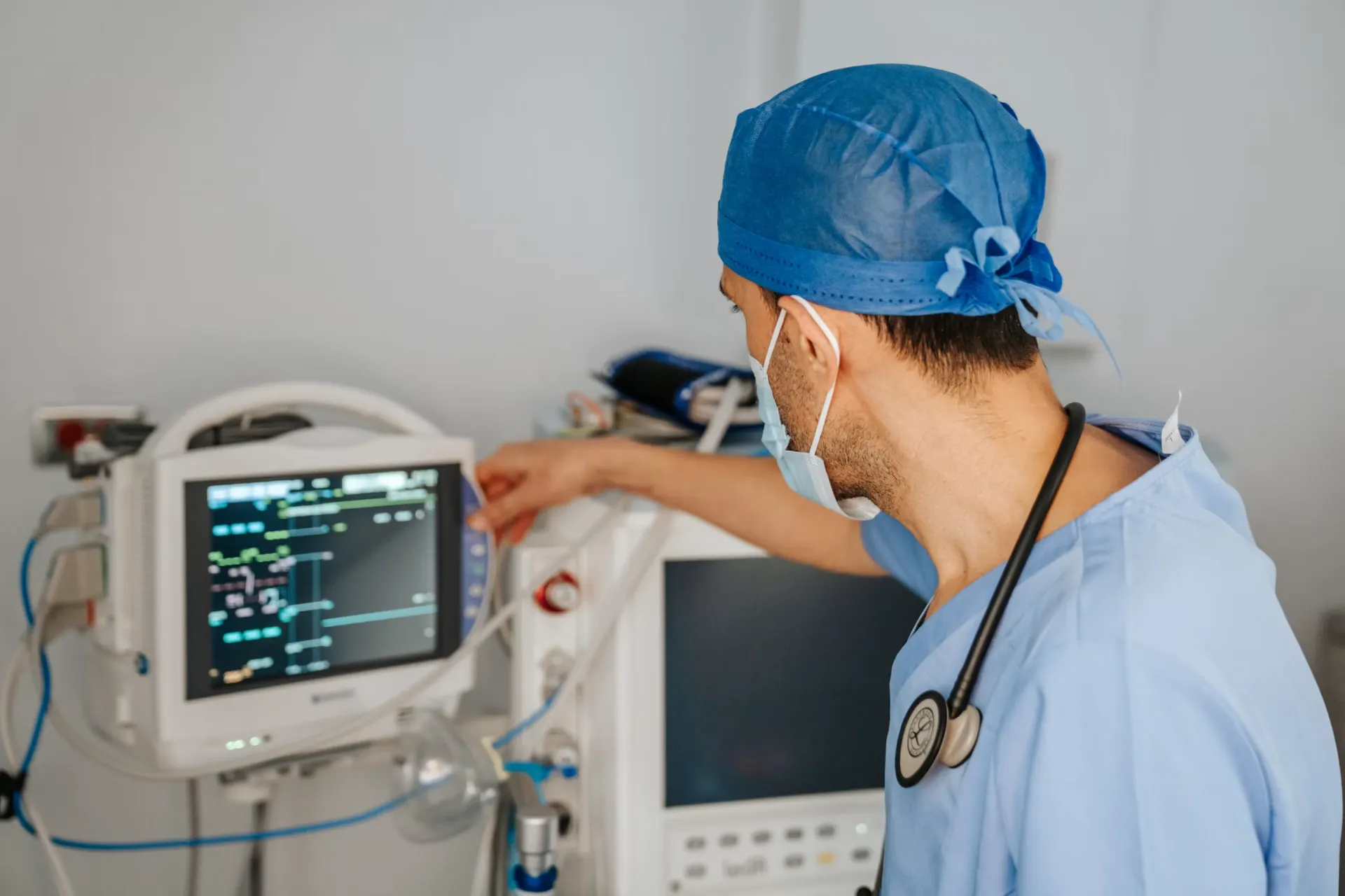 Clinician adjusting a patient monitor in a clinical setting